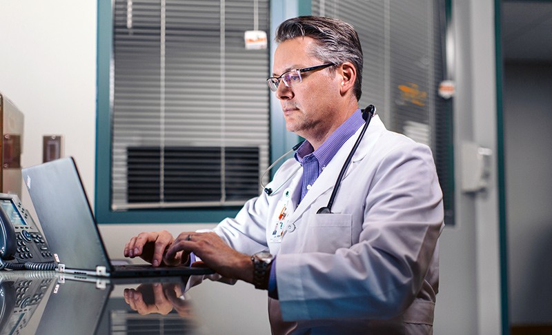 Doctor on notebook computer in office