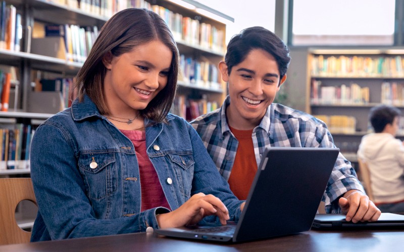 Accessibilité Two students using laptop on library