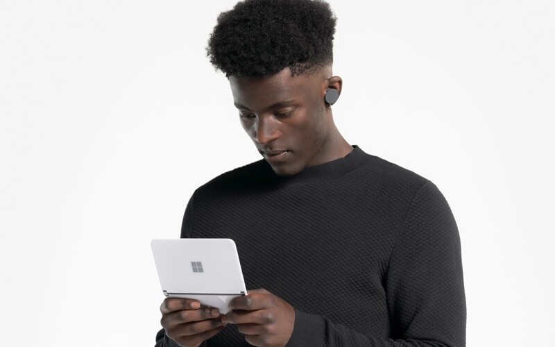 The Surface Duo is perfect for handling and protecting your business's devices, identities and data. Male half body using Surface Duo