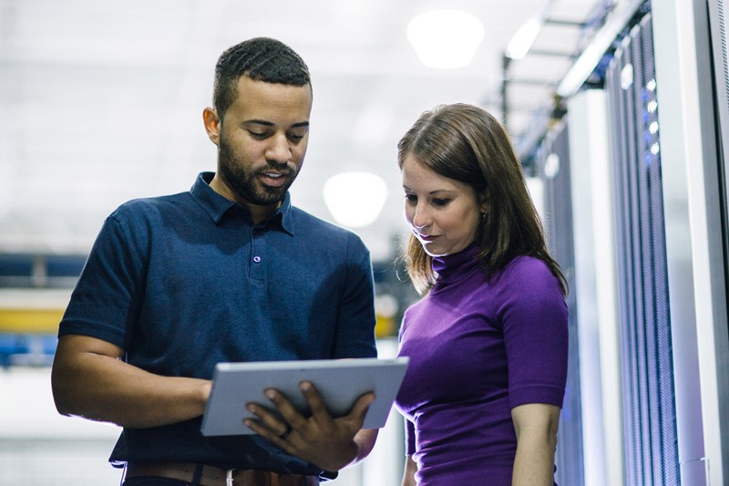 Industry-leading technology IT admin in data center on notebook computer