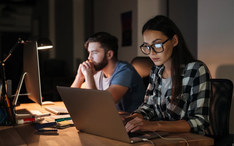 Two employees working in office at night