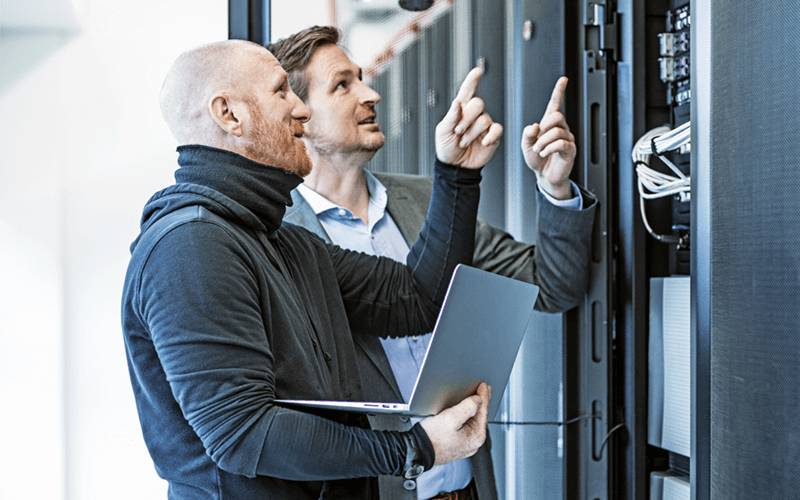 We help you detect and repair vulnerabilities before attacks occur Two IT engineers on laptop working in data center