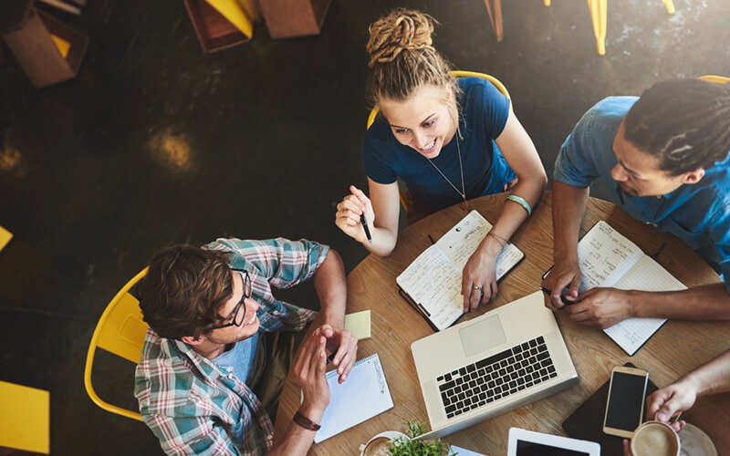 Your collaboration strategy starts here. Business professionals brainstorming ideas with various mobile technology in hand