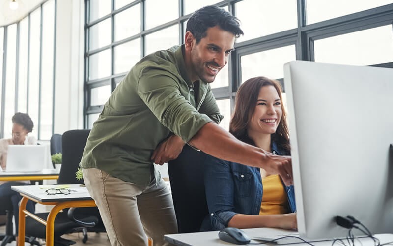 Two colleagues are able to create and innovate with a wide variety of apps on a desktop computer