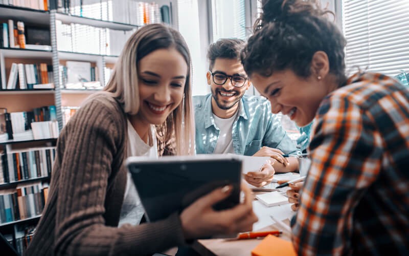 Student and staff success hinges on strong connectivity Study session in library with students on tablet