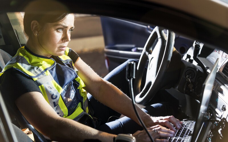 When every second counts, having the right technology can improve your speed and efficiency Female officer checks information through system in police car
