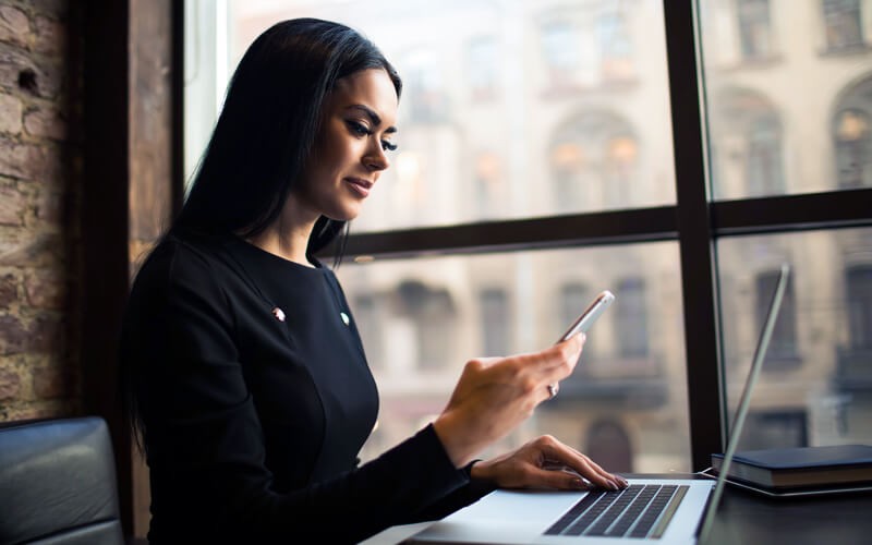 Reduce the number of applications it takes to run your organization Government official using mobile device and laptop in front of window