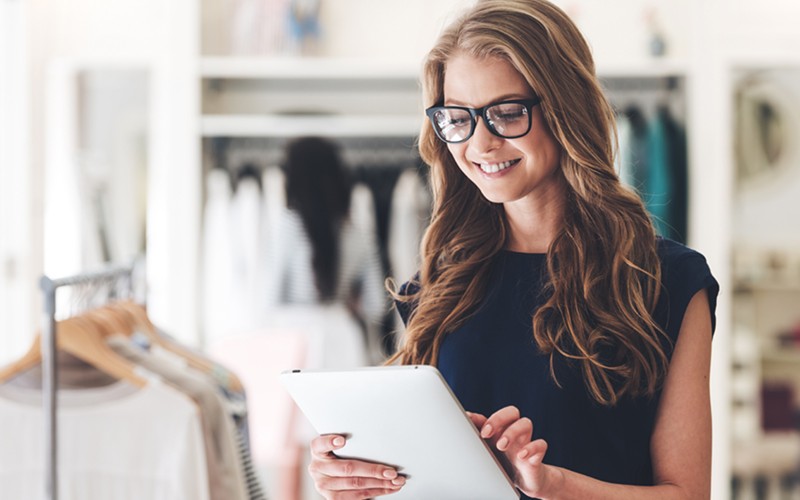 Shopping goes beyond brick-and-mortar storefronts Retail customer on tablet device in clothing store