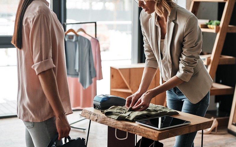 Our smart solutions cater to businesses of all sizes Small business owner of clothing store rings up customer