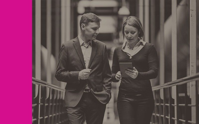 Track assets moving through each lifecycle stage effectively. Man and woman walking down data center hallway with tablet