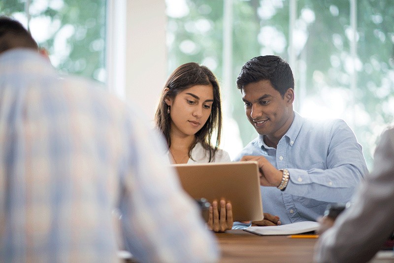 Two professionals collaborating with tablet device Manage technology deployement
