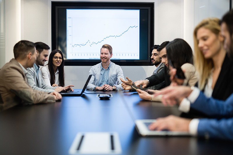 Spend more time driving business growth Team meets in conference room to discuss business goals and objectives using multiple mobile devices