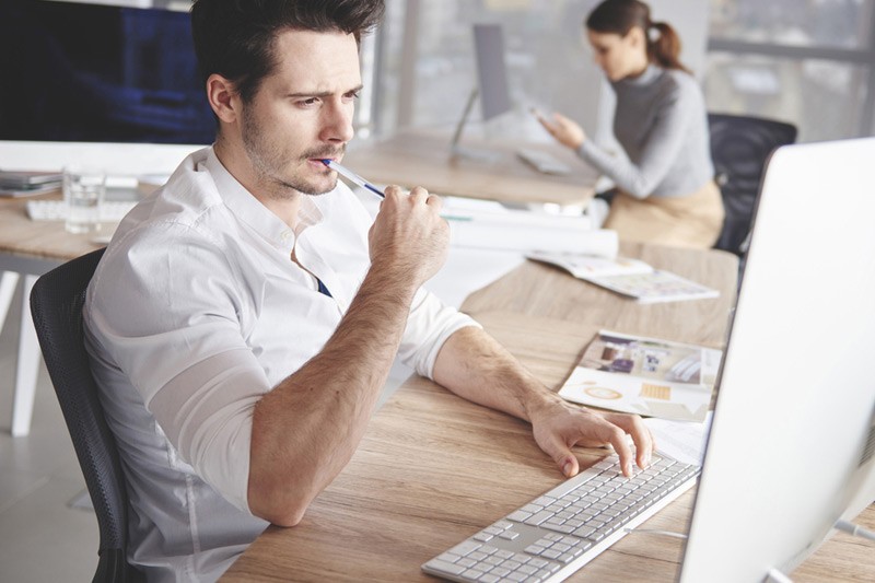 Personalized product offerings Businessman with pen works at laptop computer