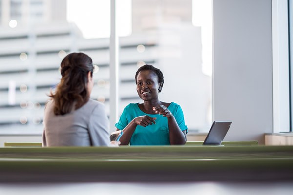 Flexible financing and leasing services Two business woman discuss technology leasing and financing at table