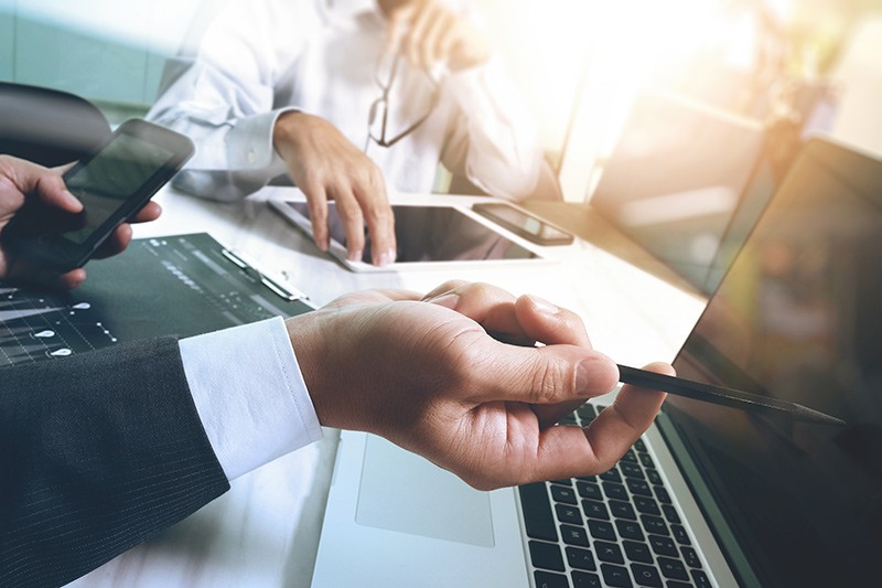 Stay relevant and runs more efficiently Business professionals have meeting while using multiple mobile devices